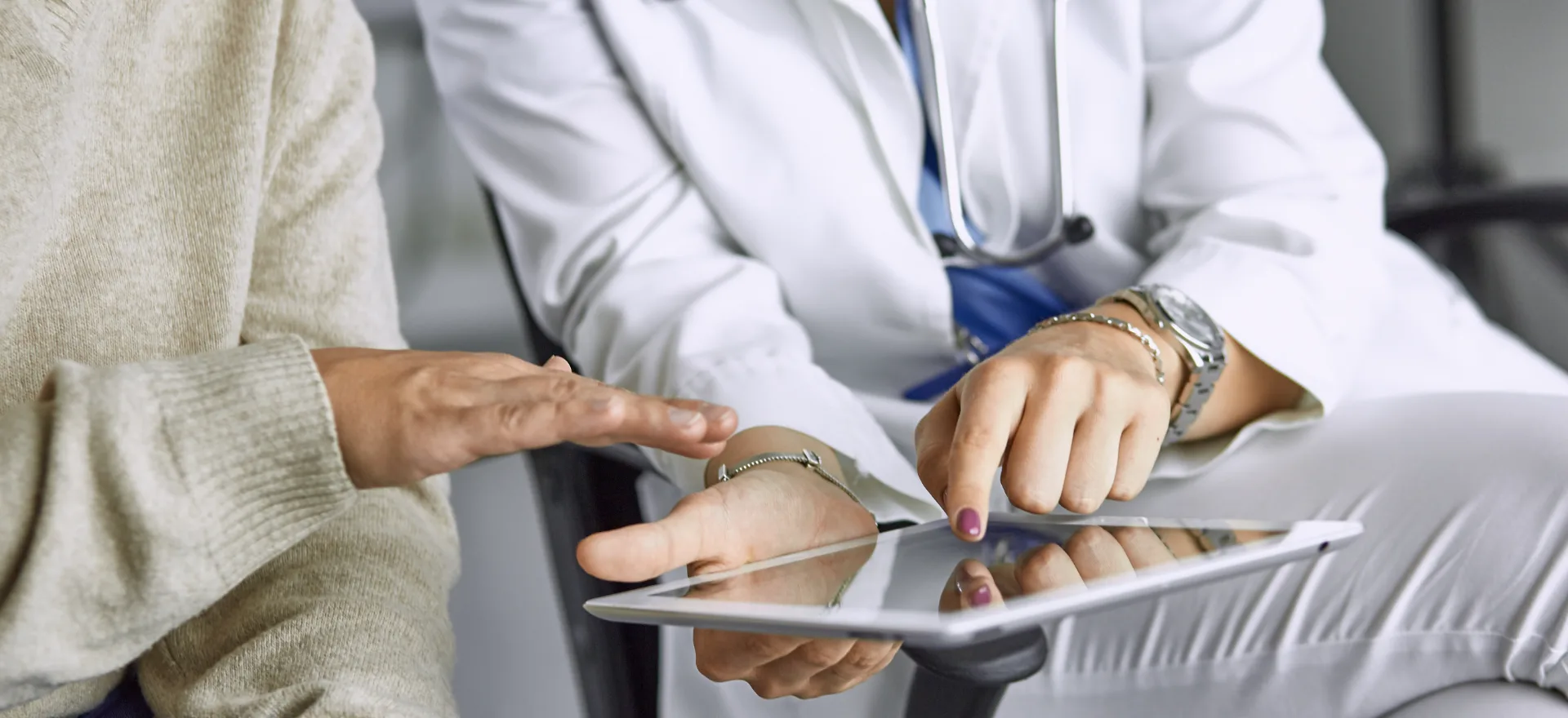 A female physician reviewing information with a patient on a tablet